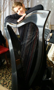 Anne Roos standing next to her carbon fiber harp