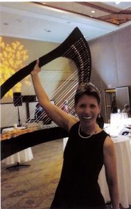 Anne Roos lifting her harp